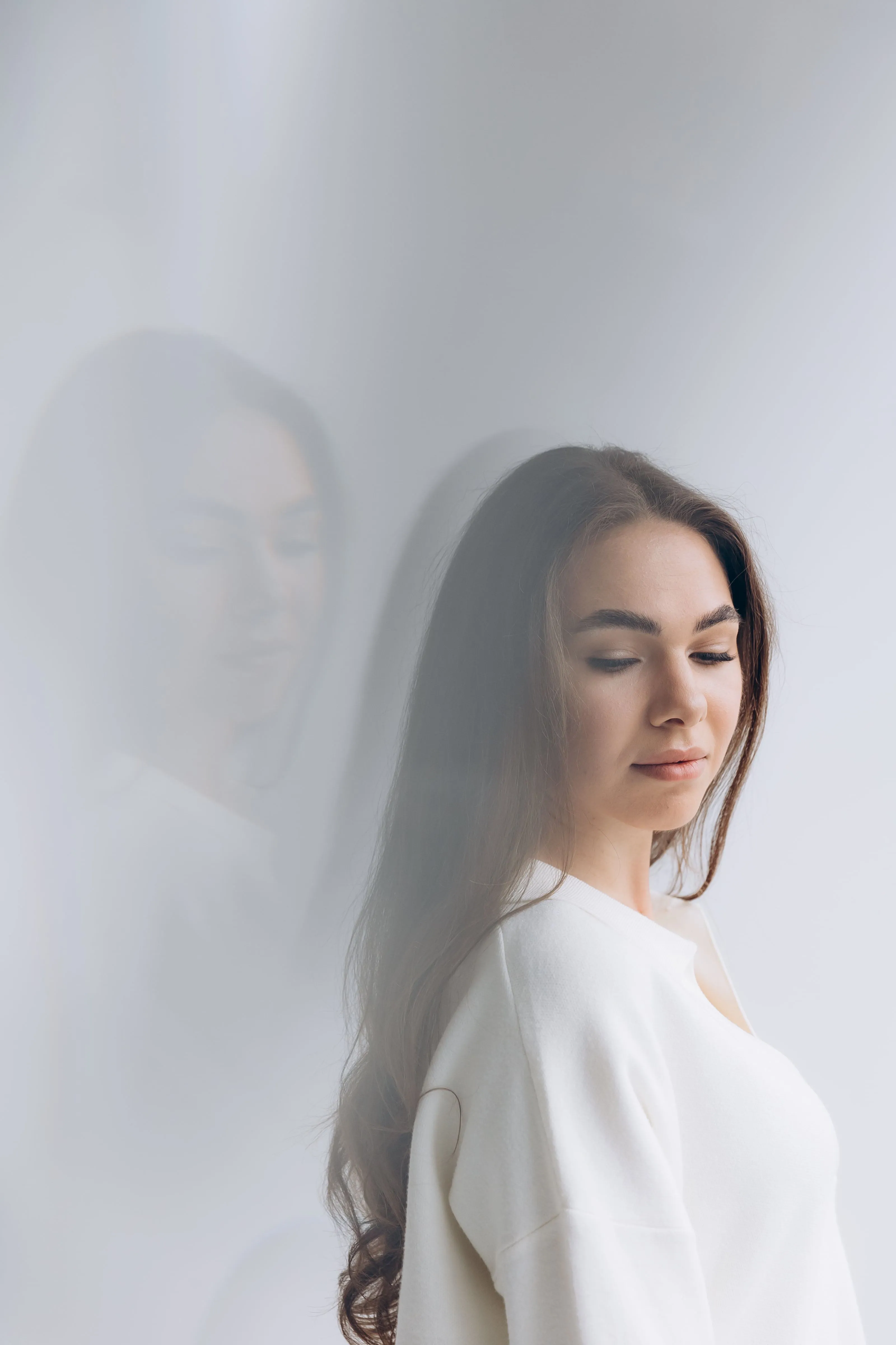 a woman standing in front of a white wall