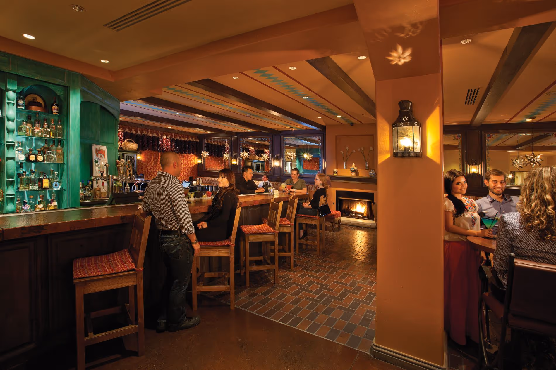 Interior of Garduno's Restaurant with people at a bar and fireplace in background