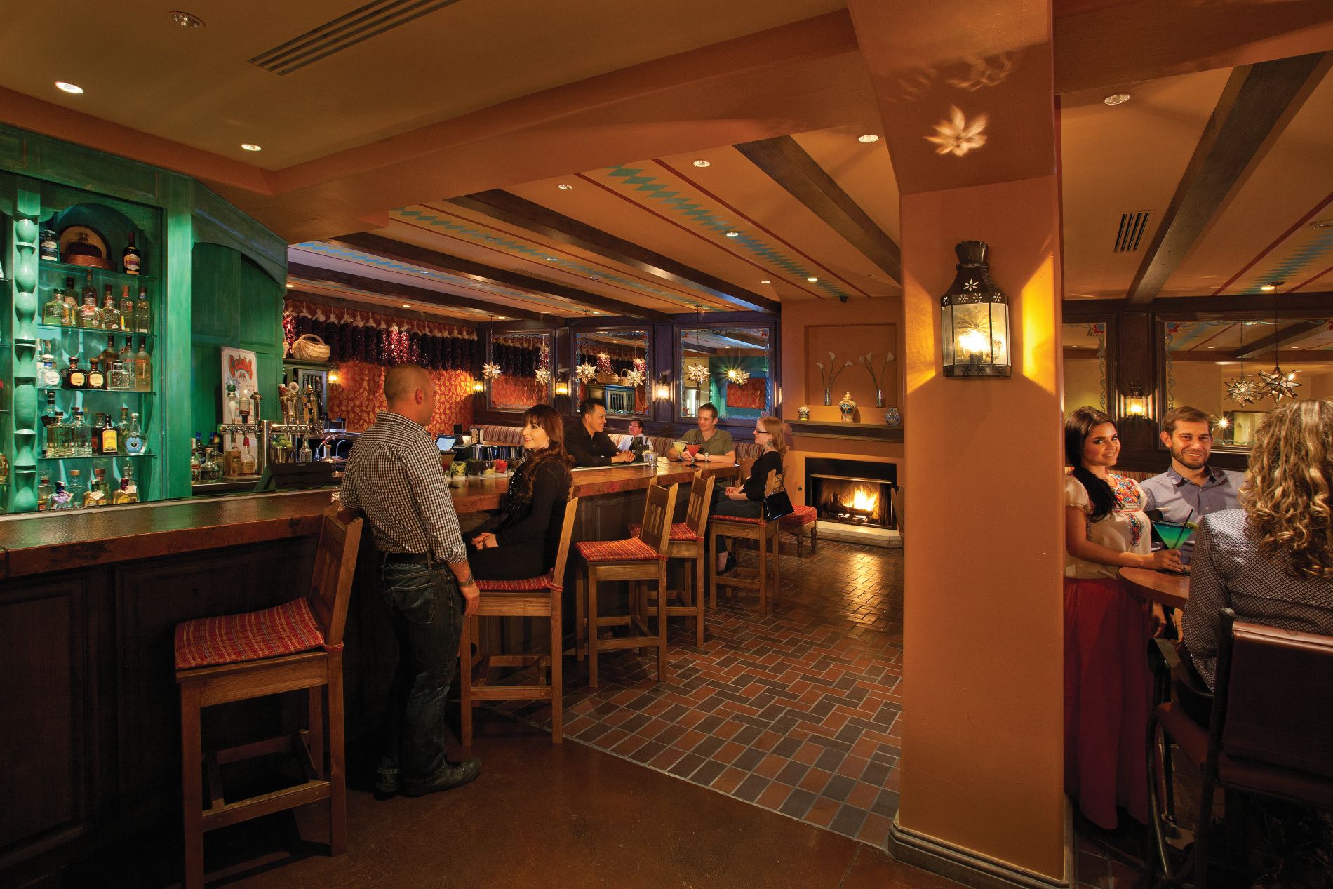 Interior of Garduno's Restaurant with people at a bar and fireplace in background