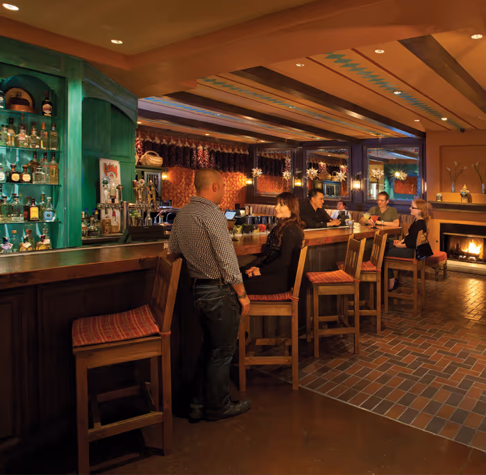 Garduno's dining room with people sitting at a bar and fireplace