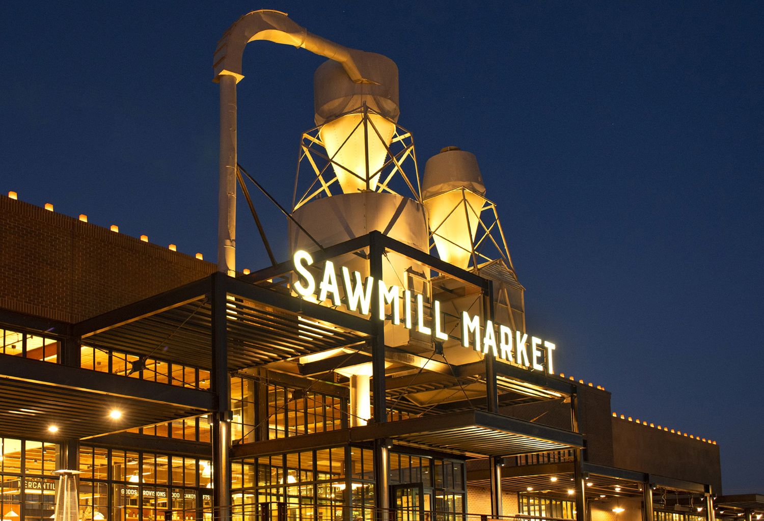 Sawmill Market entrance at night with luminarias