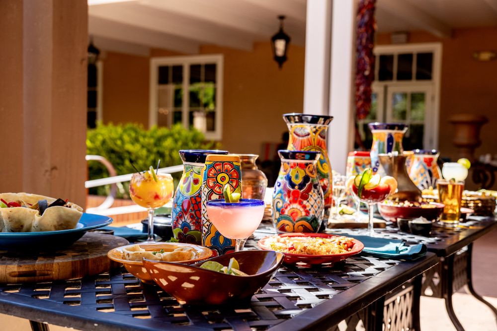 Table outside on Garduno's patio with colorful dishware plates of food and margaritas
