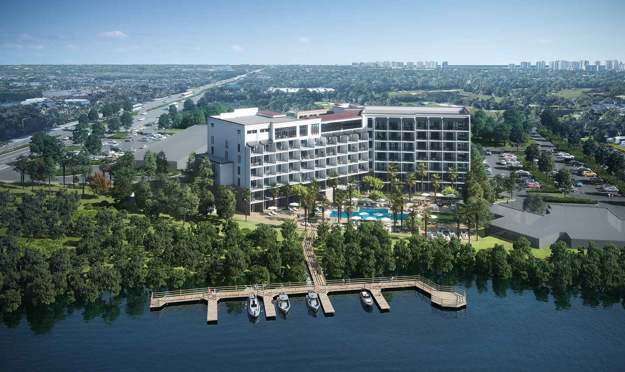 Aerial view of a waterfront hotel with pool, dock, and surrounding greenery.