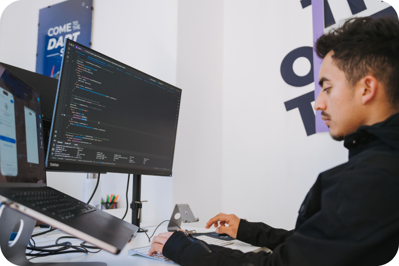 Somnio engineer working on code across several monitors