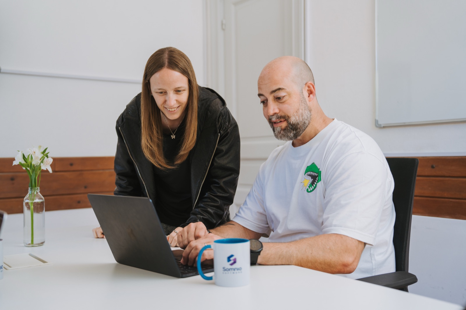Two Somnio team members reviewing work together on a laptop