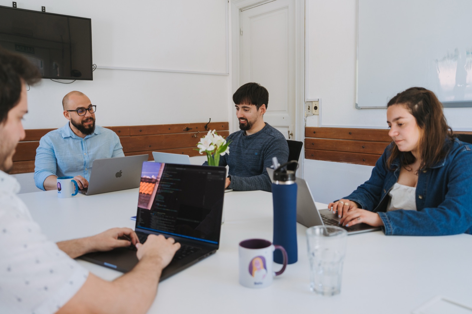 Somnio engineers working on laptops around a meeting table