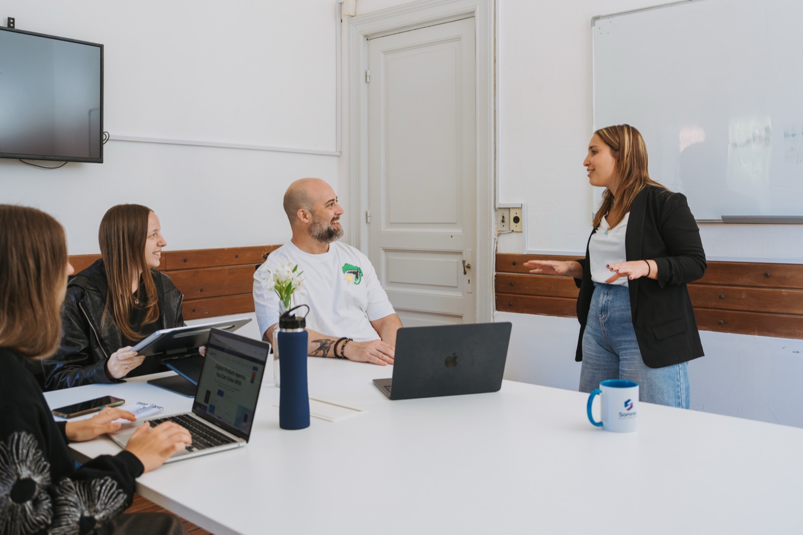A Somnio team meeting around a table with laptops