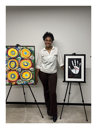 Lauren standing next to two of her framed art pieces