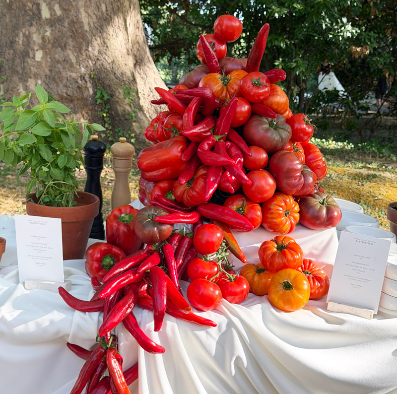 Scénographie culinaire de buffet de mariage composée de tomates et piments frais de saison