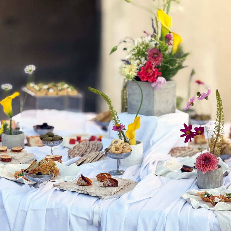 Buffet de mariage scénographié avec bouchées gourmandes, fleurs fraîches et présentation sur mesure par La Dame Bleue