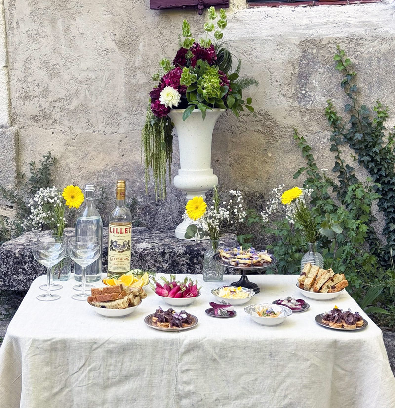 Buffet de mariage en extérieur avec bouchées apéritives, fleurs et mise en scène méditerranéenne