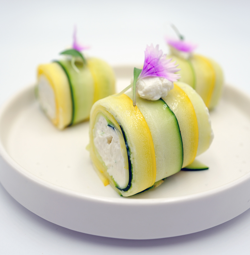 Bouchées végétales aux courgettes et fleurs comestibles pour un buffet de mariage végétarien.