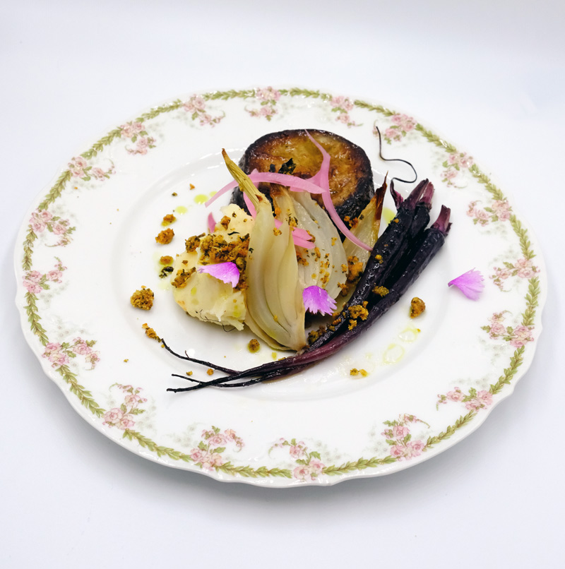 Assiette végétale de saison avec légumes rôtis et fleurs comestibles pour un service traiteur mariage