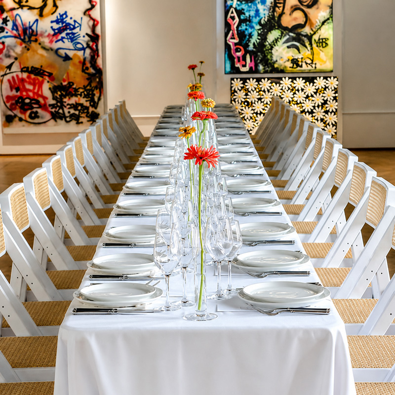 Grande table dressée avec fleurs et vaisselle pour une soirée d’entreprise organisée par La Dame Bleue.