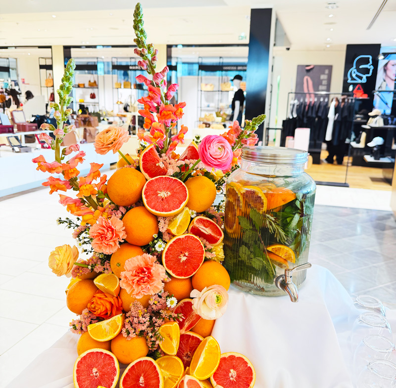 Scénographie culinaire aux agrumes, fleurs et eau infusée pour un événement de marque en showroom