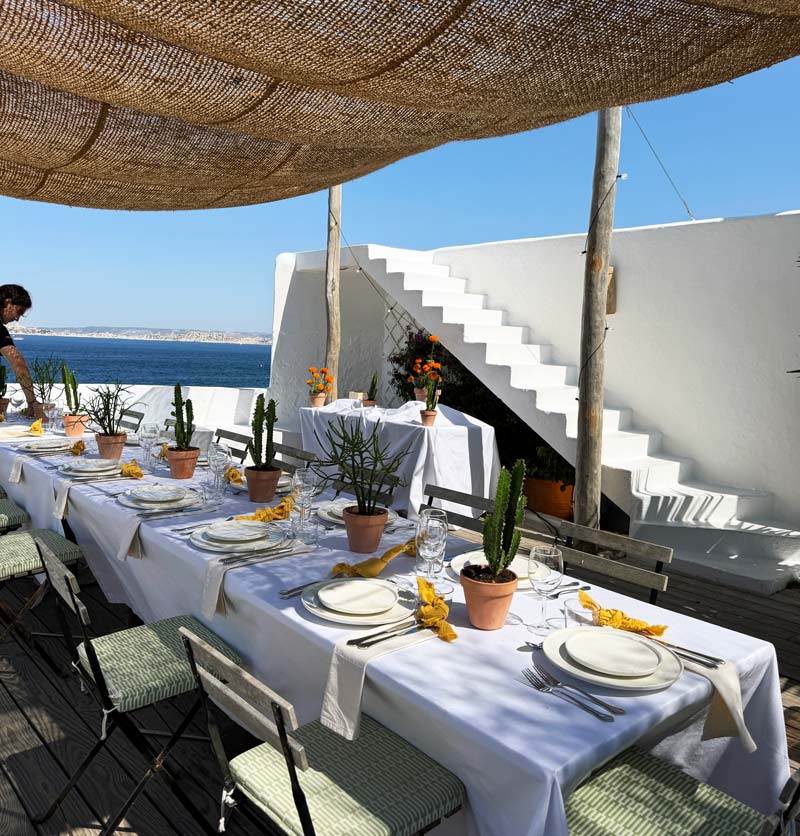 Table dressée en terrasse face à la mer pour un dîner privé de marque ou de production