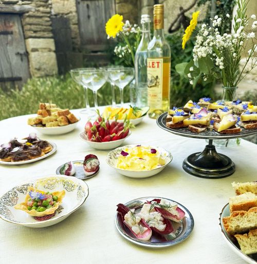 Buffet traiteur à domicile avec bouchées salées, légumes de saison et présentation florale en extérieur