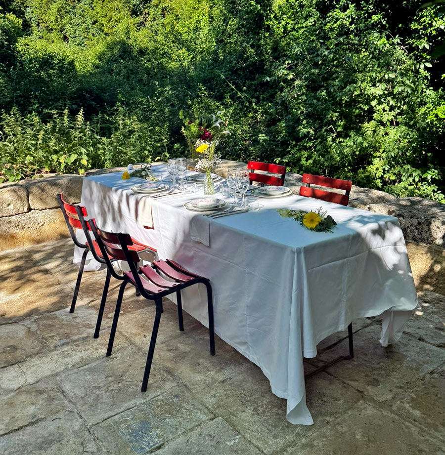 Table dressée en extérieur pour un dîner privé avec service de traiteur à domicile