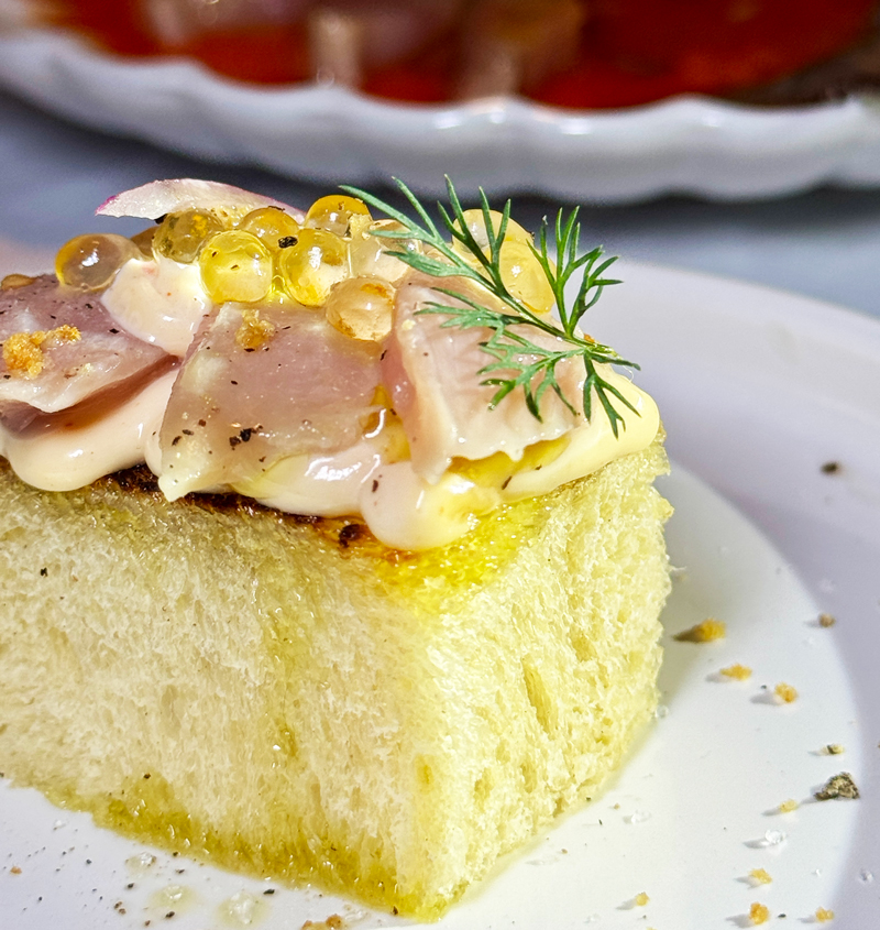 Bouchée de poisson sur pain brioché avec sauce et herbes fraîches pour un service à l’assiette