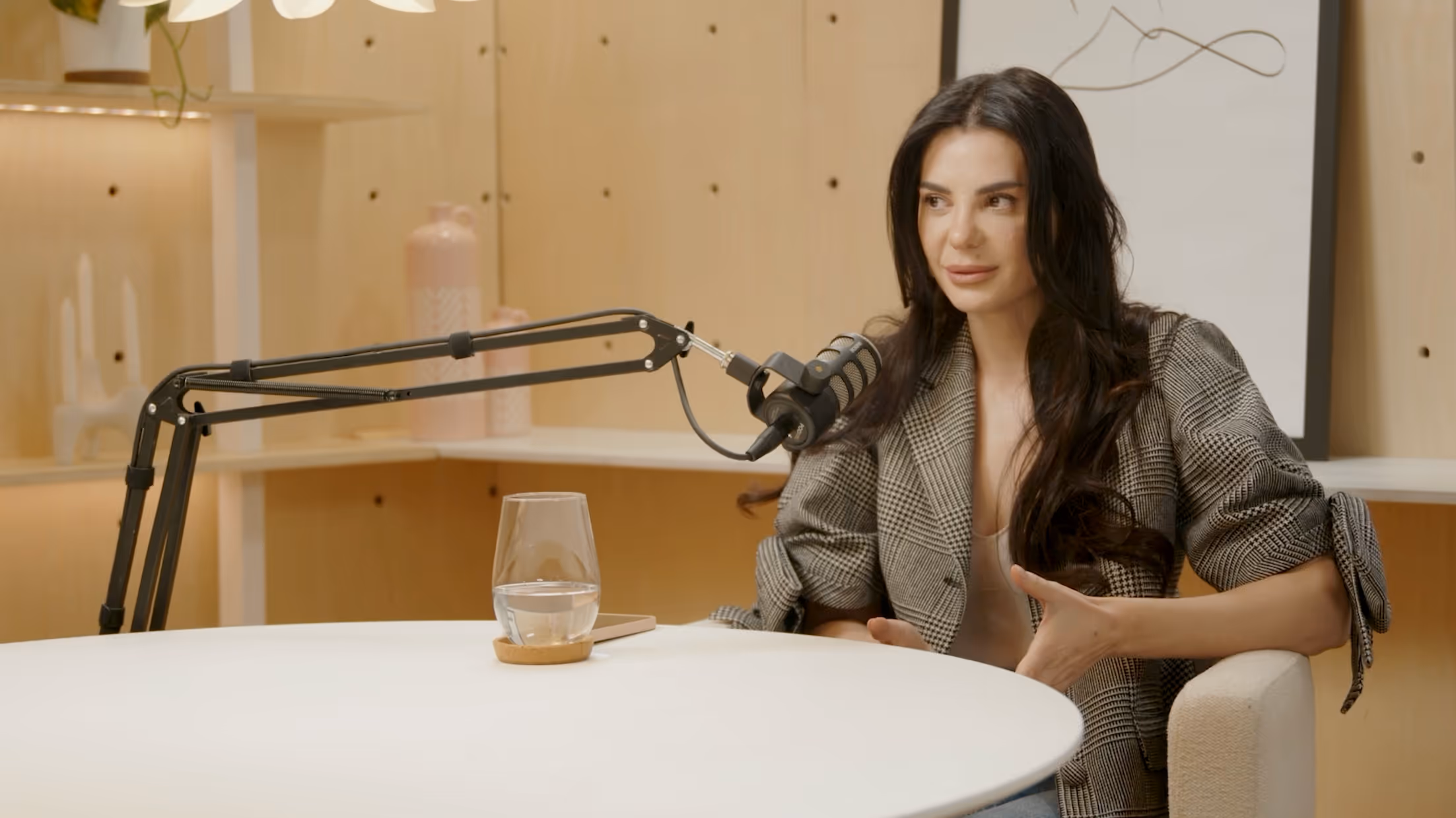 a woman sitting at a table with a microphone