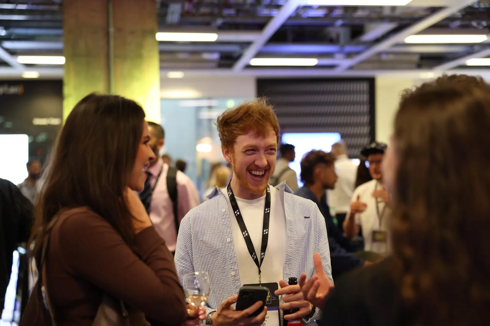 An attendee laughing in conversation at the evening drinks