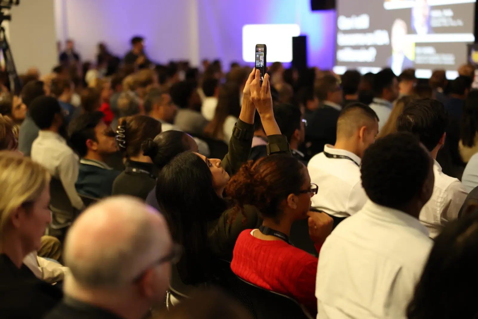 An audience member filming a session on her phone