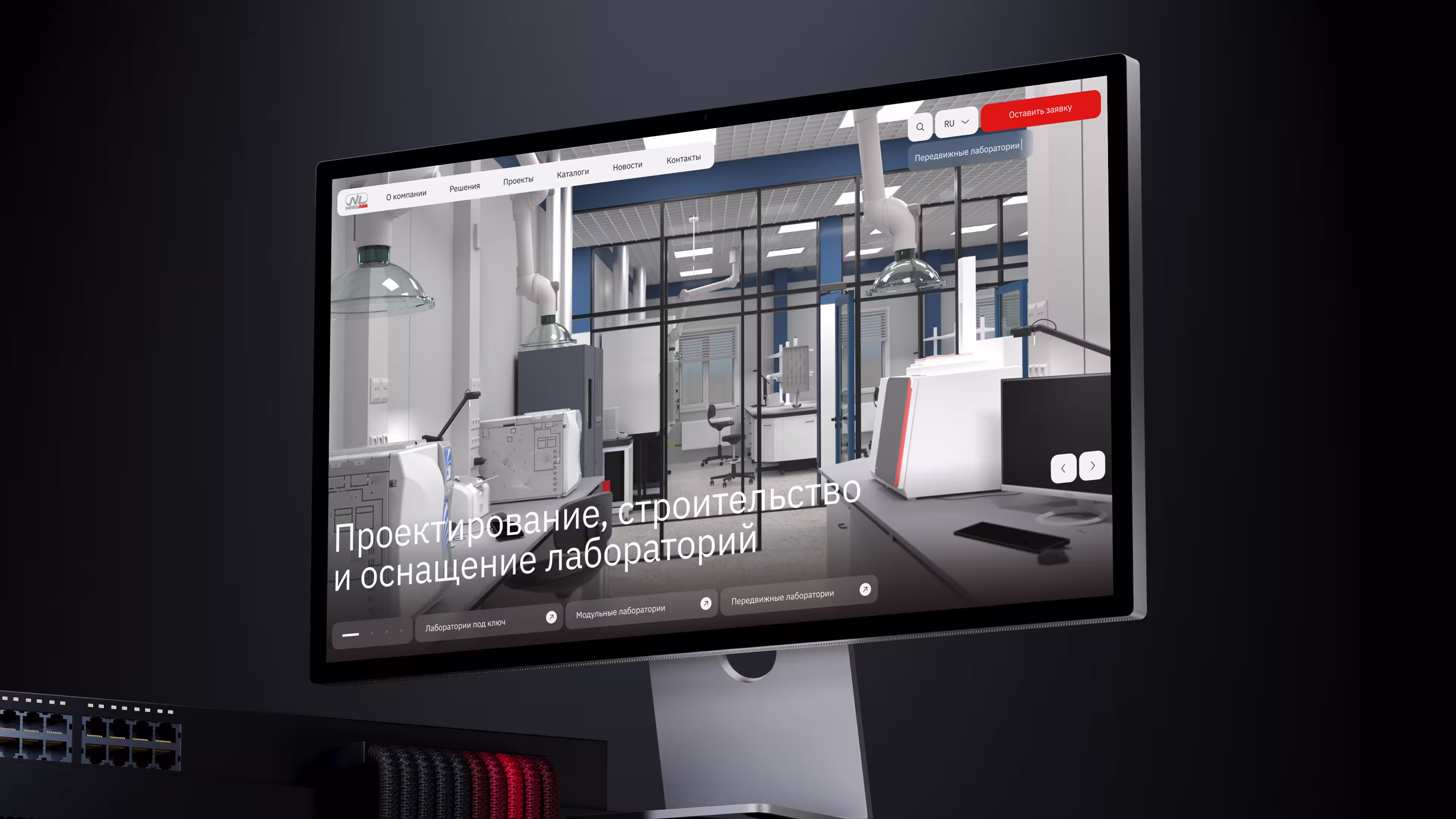Computer monitor showing a modern laboratory interior with lab equipment and ventilation hoods.