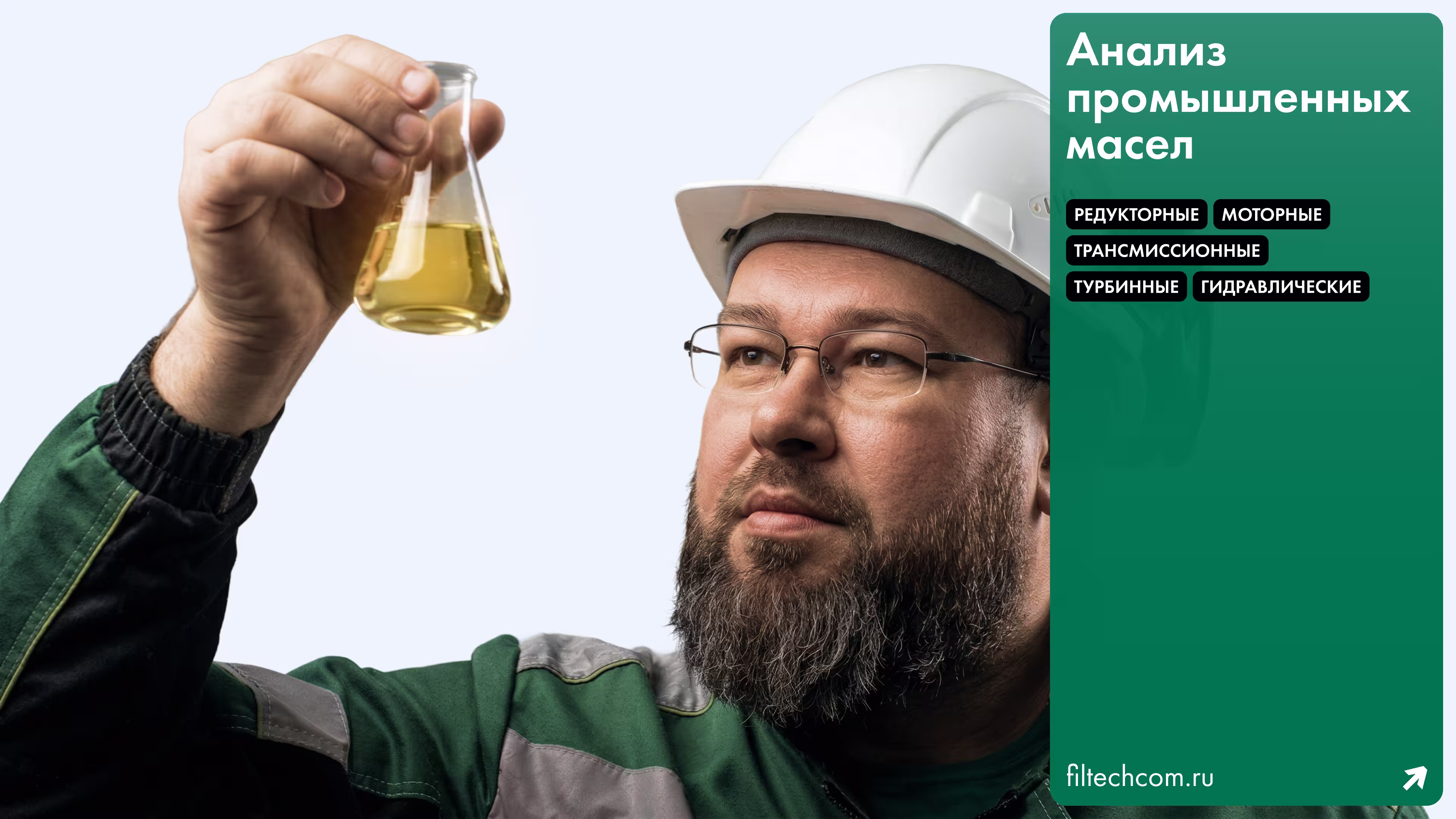 Man in a hard hat and glasses inspecting yellow liquid in a flask against a light background.