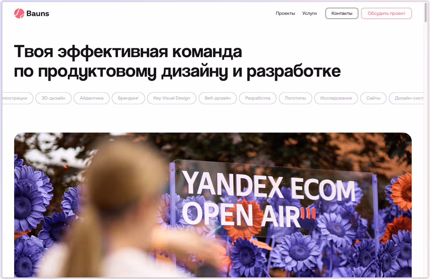 Website header in Russian about product design with blurred person, purple flowers, and YANDEX ECOM OPEN AIR sign.