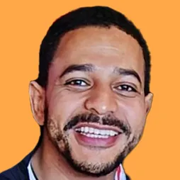Smiling man with short hair and beard against an orange background.
