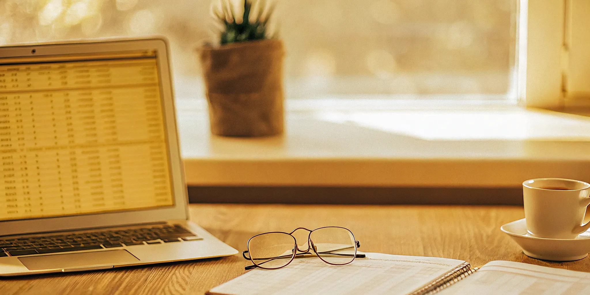 Accounting spreadsheet on a laptop with glasses and coffee. Discounts in accounting best practices.