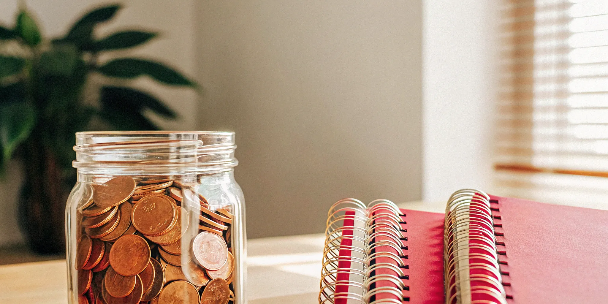 Deferred revenue vs. backlog: Coins and notebooks symbolize financial tracking.