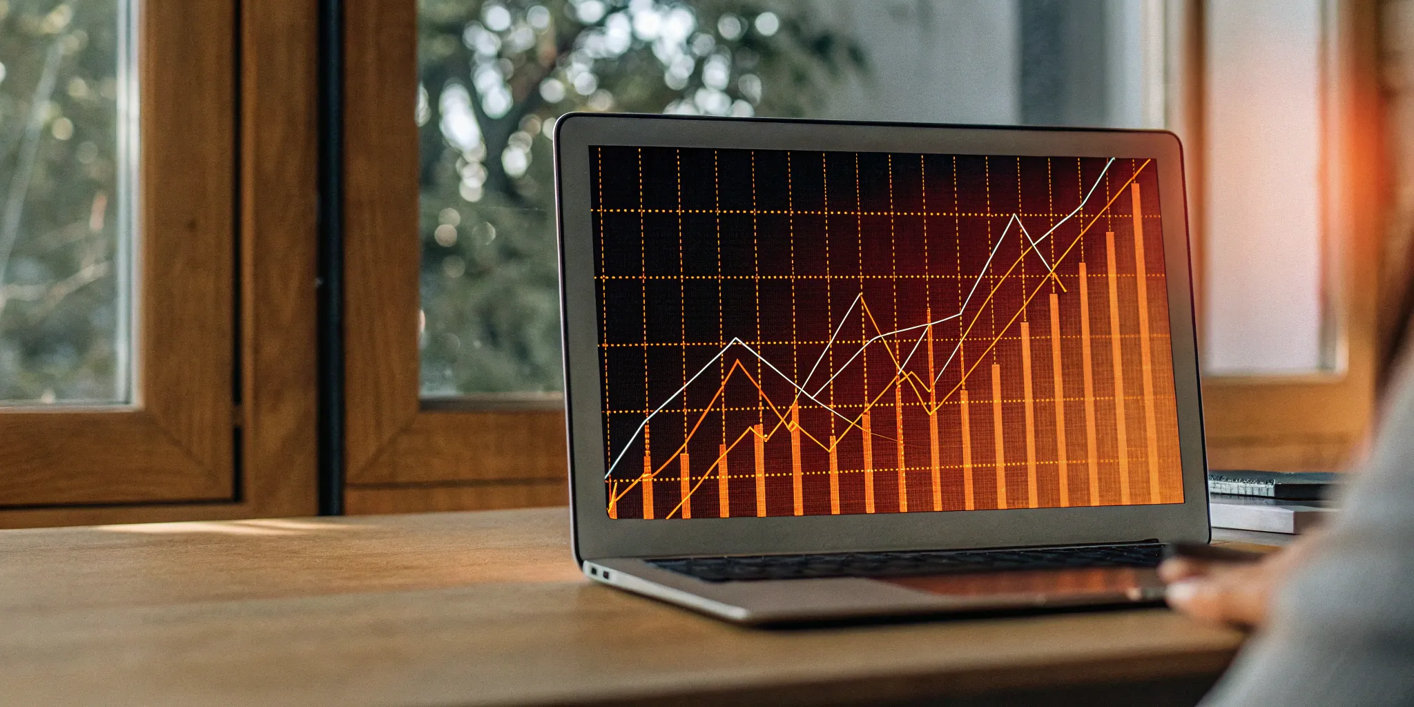 Revenue backlog graph trending upwards on a laptop screen.