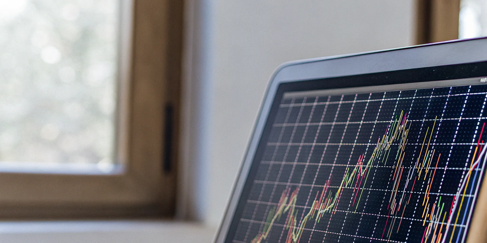 Financial data charts and analytics displayed on a laptop.