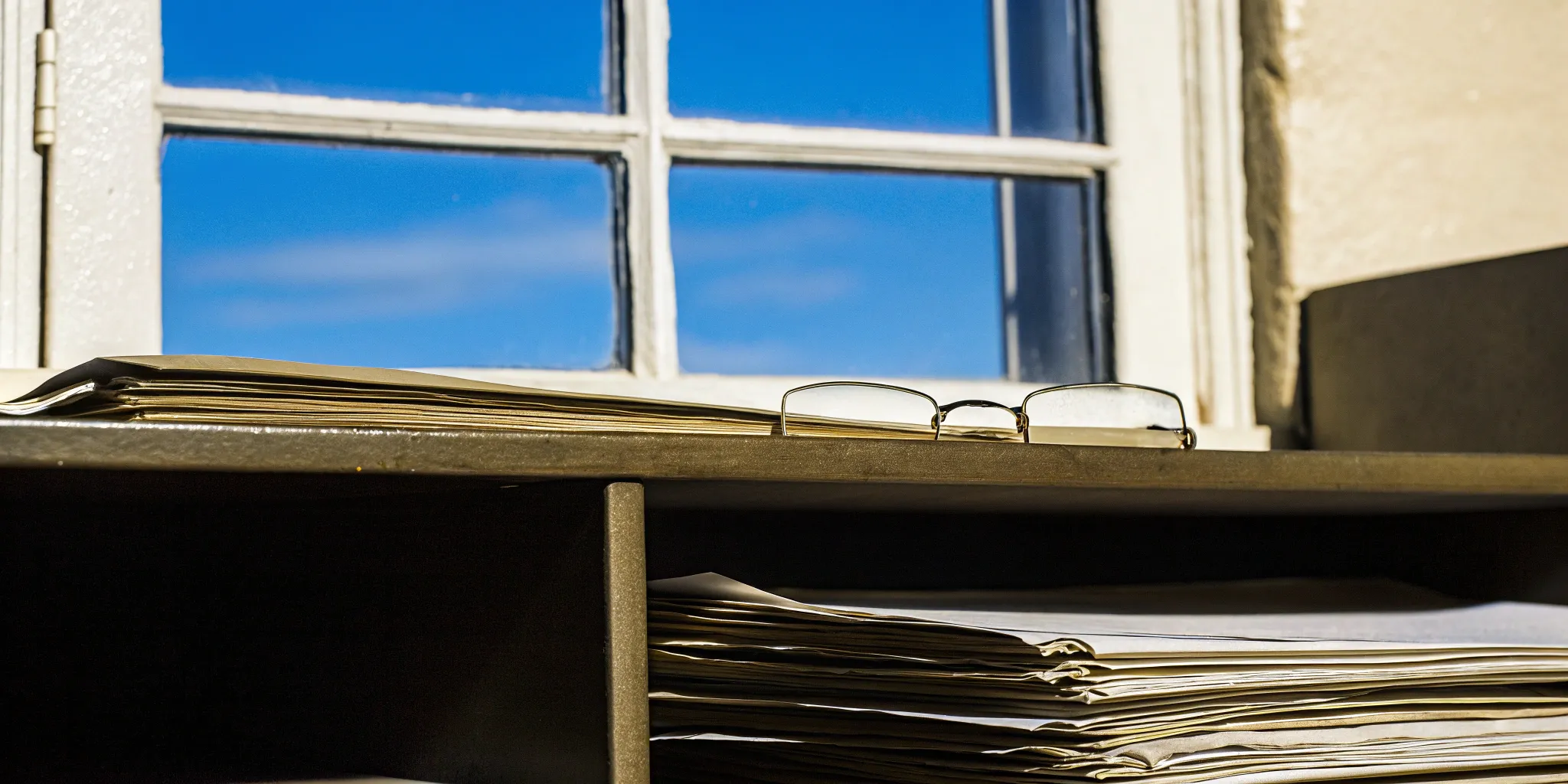 Stack of IFRS 15 disclosure checklist documents and reading glasses on a desk.