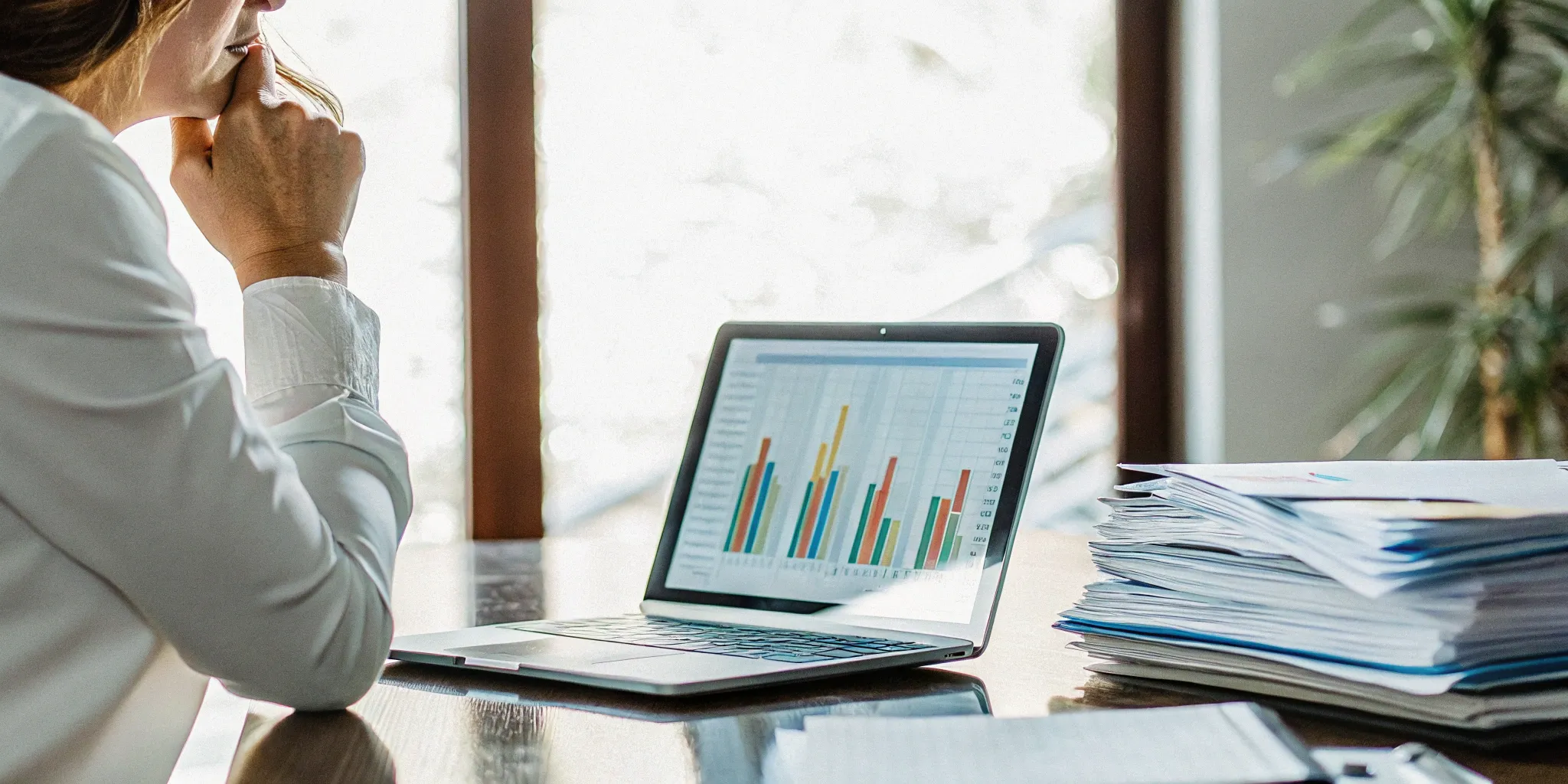 Business professional analyzing variable consideration under ASC 606 on a laptop with financial charts.