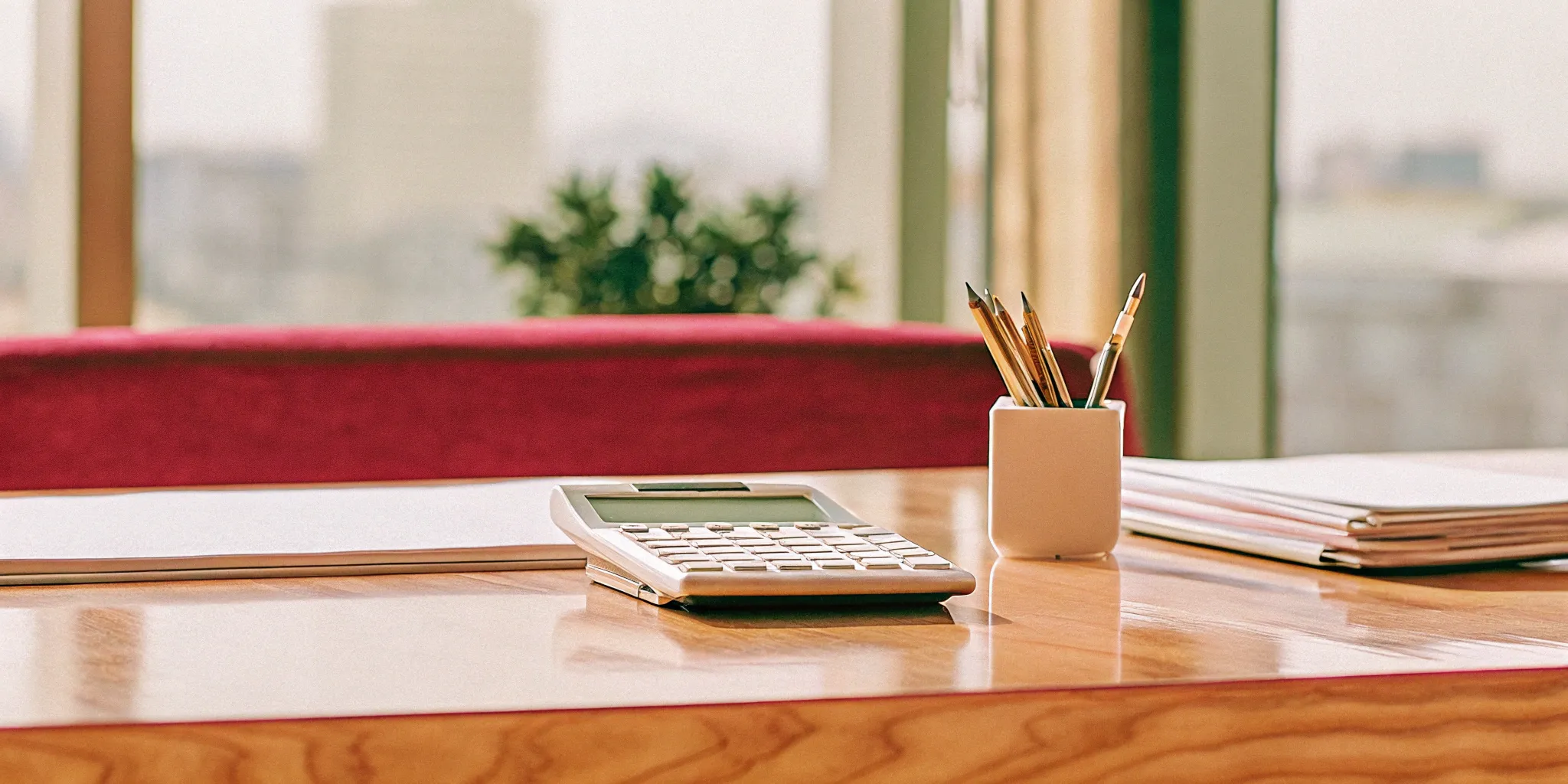 Desk with financial documents and a calculator used to audit revenue recognition.