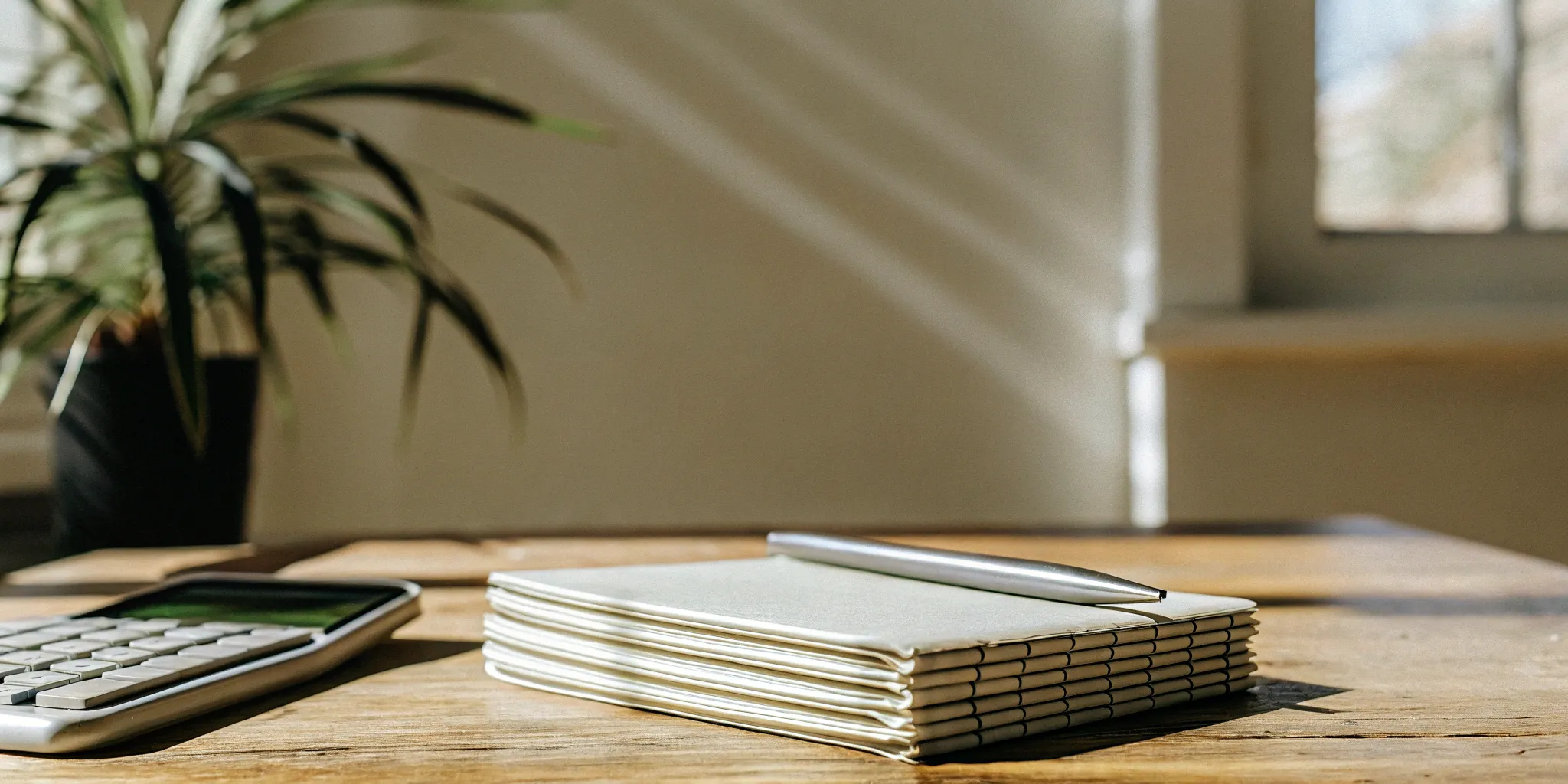 A calculator and pen on an accounting journal for recording a chargeback entry.