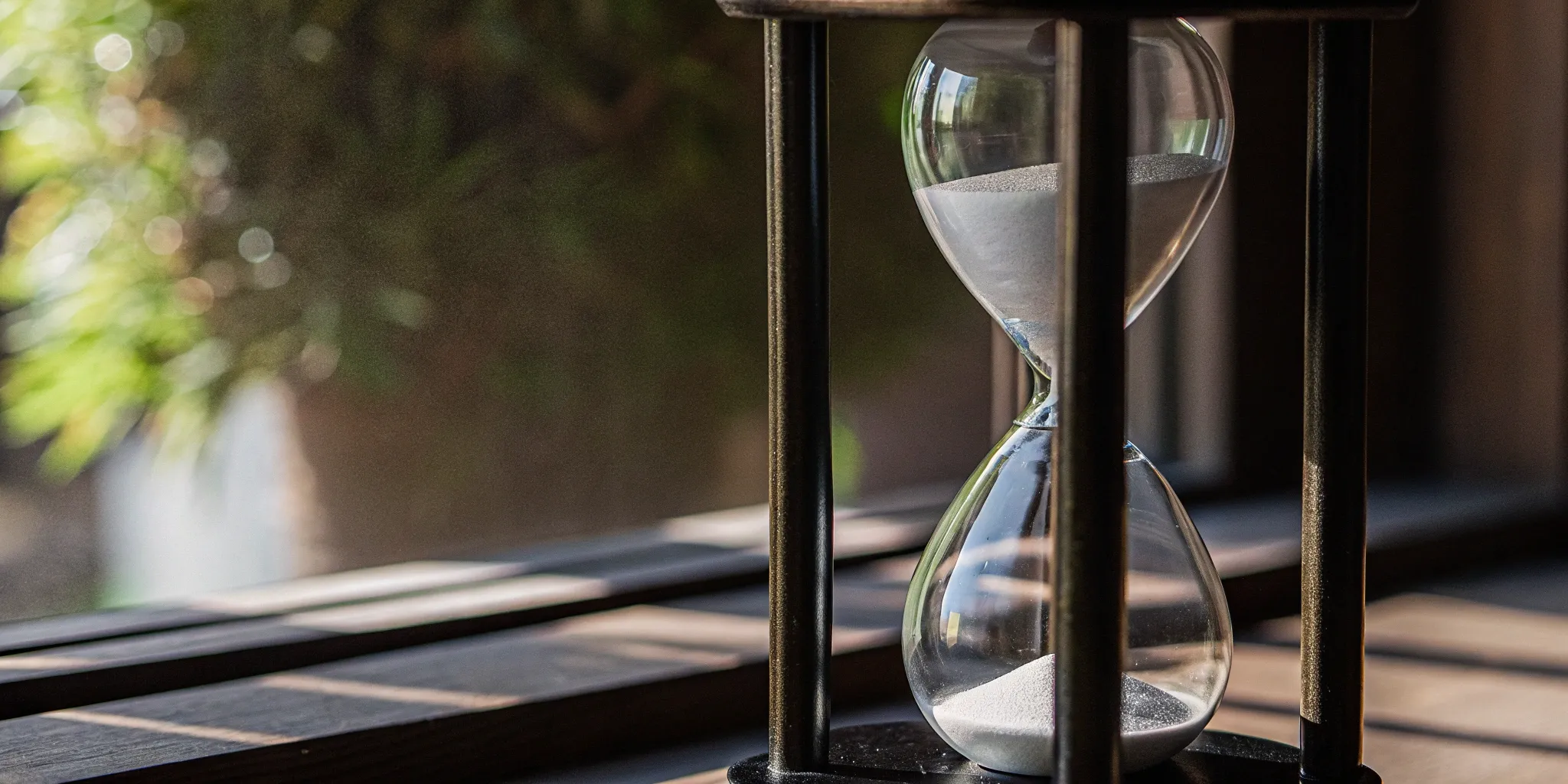An hourglass comparing over time vs point in time revenue recognition methods.