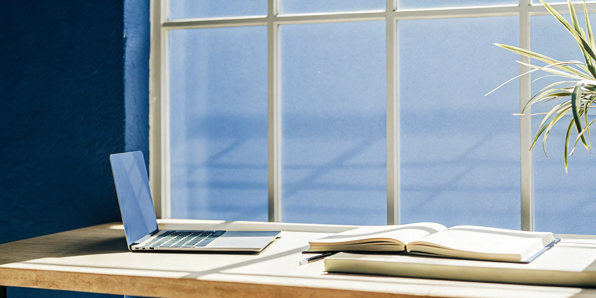 A laptop and notebook on a desk for managing the GAAP revenue recognition process.