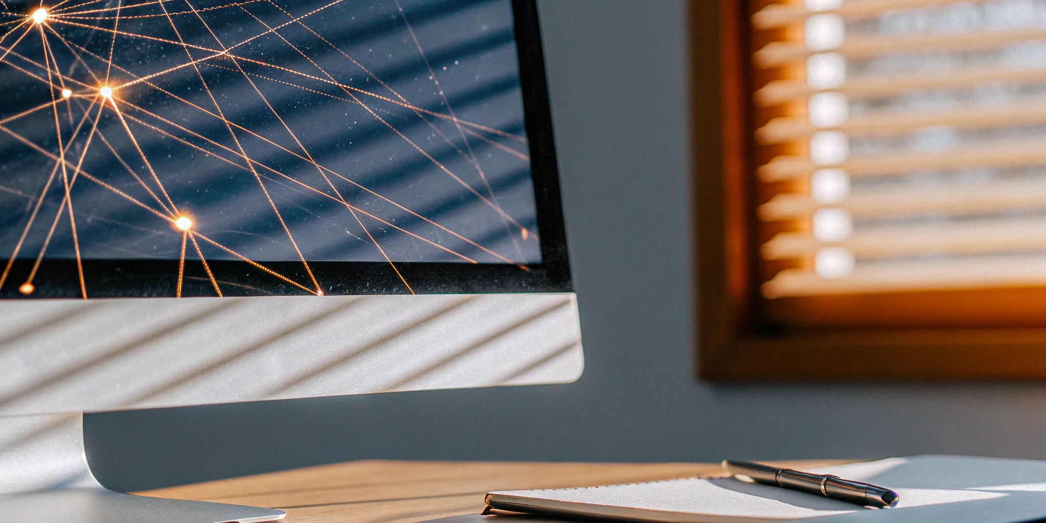 A computer screen showing automated journal entries next to a notebook and pen.