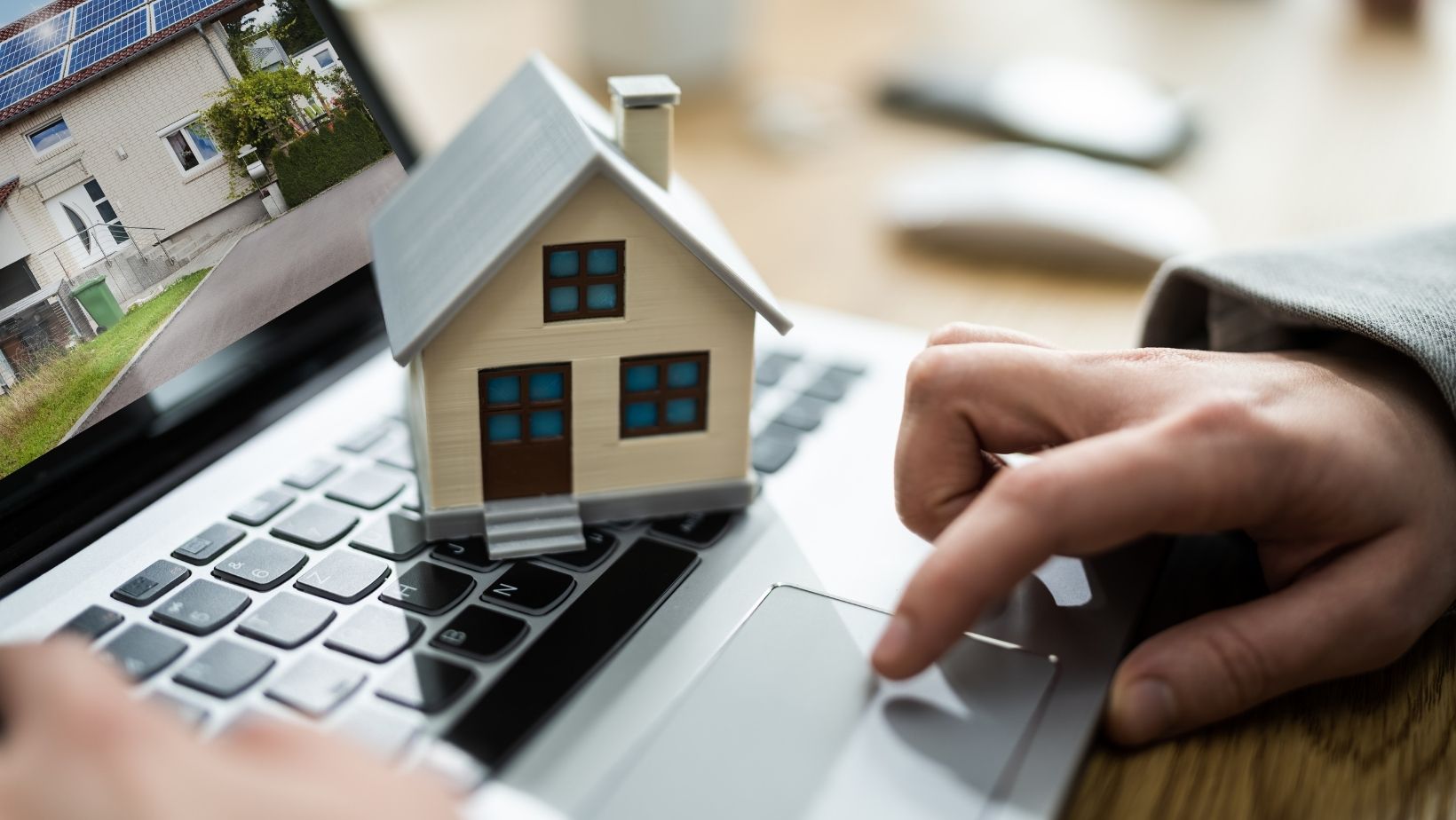 Een kleine voorbeeld woning op het toetsenbord van een laptop