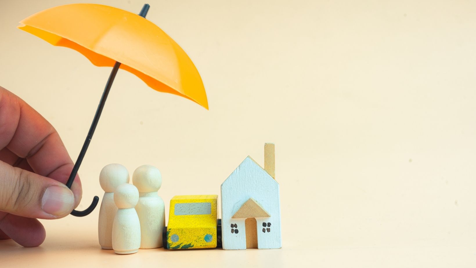 Een paraplu met daaronder een huis, personen en een auto