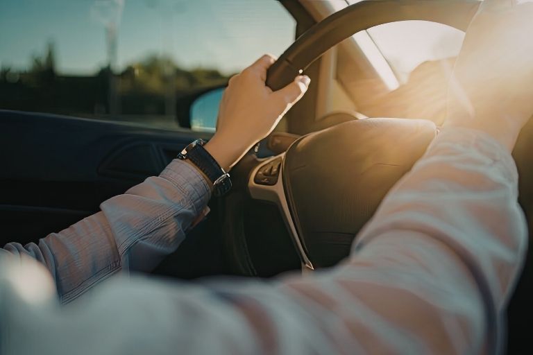 Handen aan een autostuur