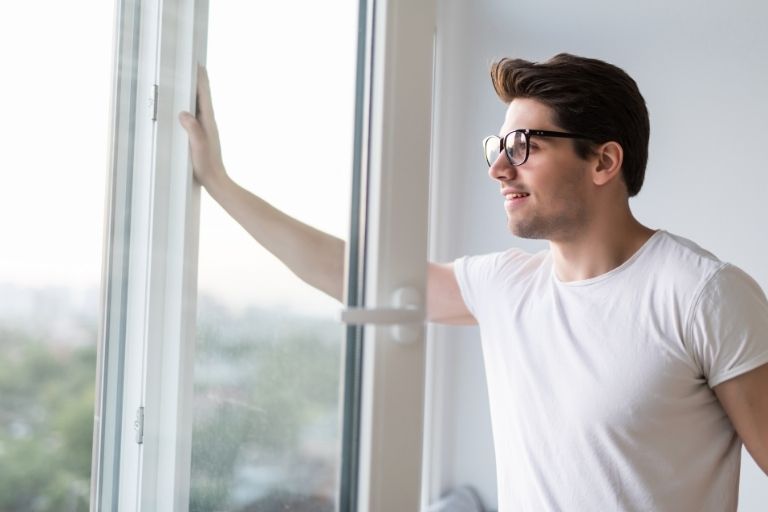 Jonge man bij open raam
