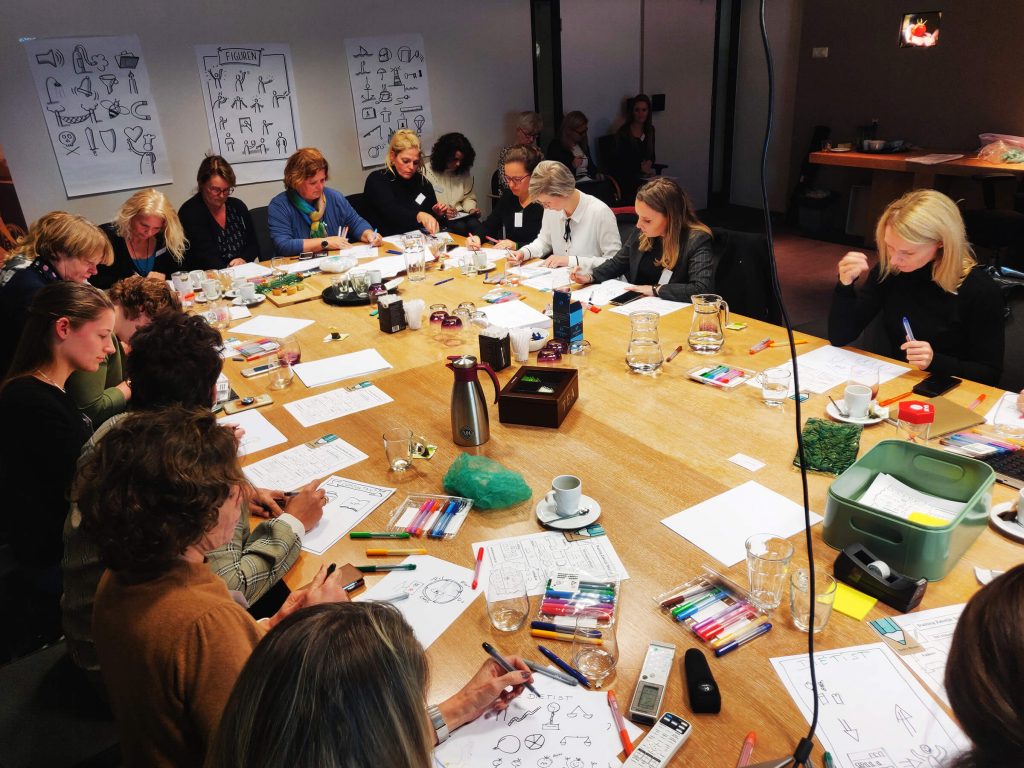 Groep mensen in vergaderruimte tijdens workshop Zakelijk Tekenen