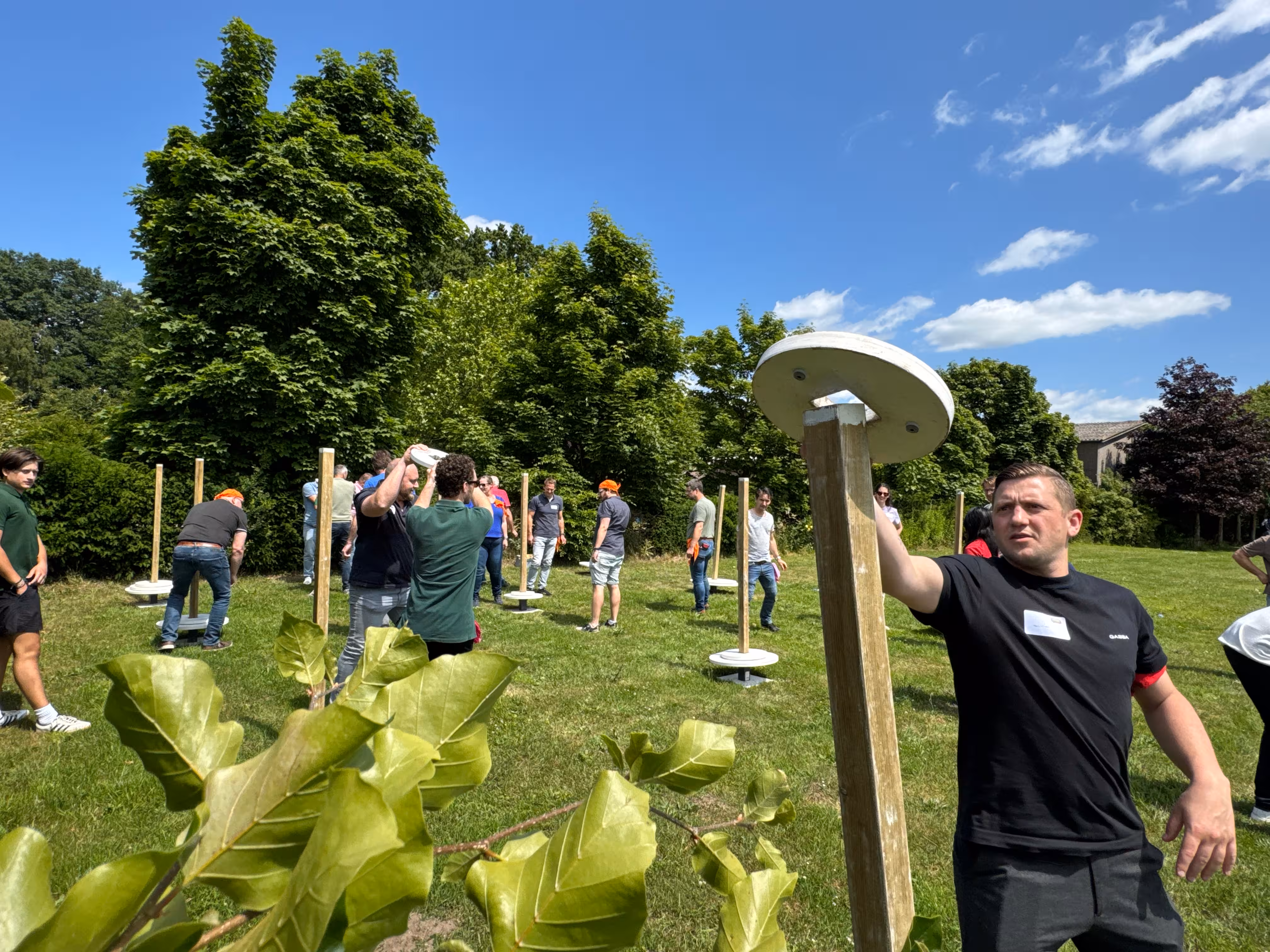 Een man legt een witte schijf om een houten balk heen tijdens de Expeditie Robinson