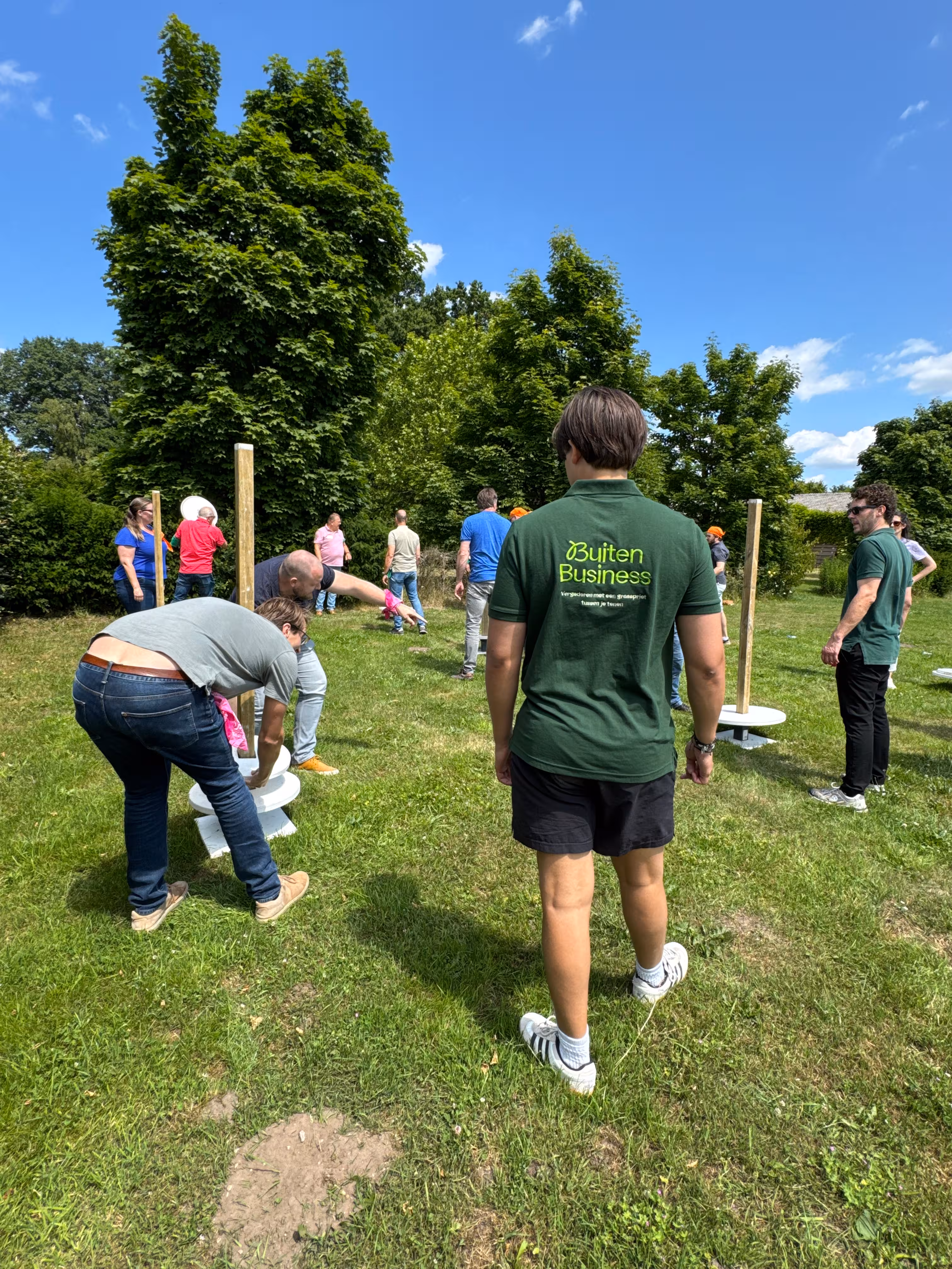 BuitenEvents instructeur kijkt naar de groepen die een toren van schijven proberen te maken