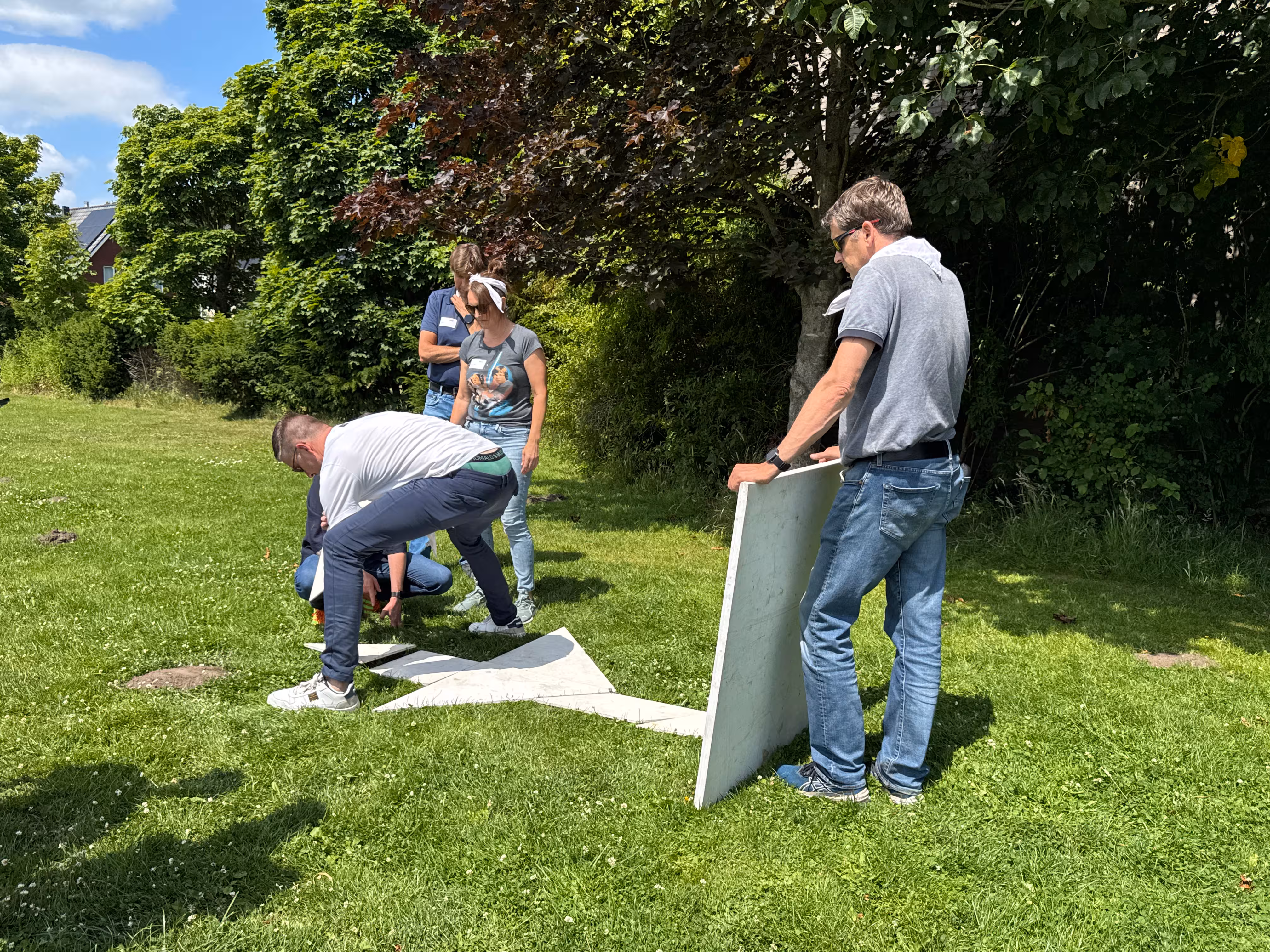 Het team probeert een figuur te maken tijdens de tangram opdracht