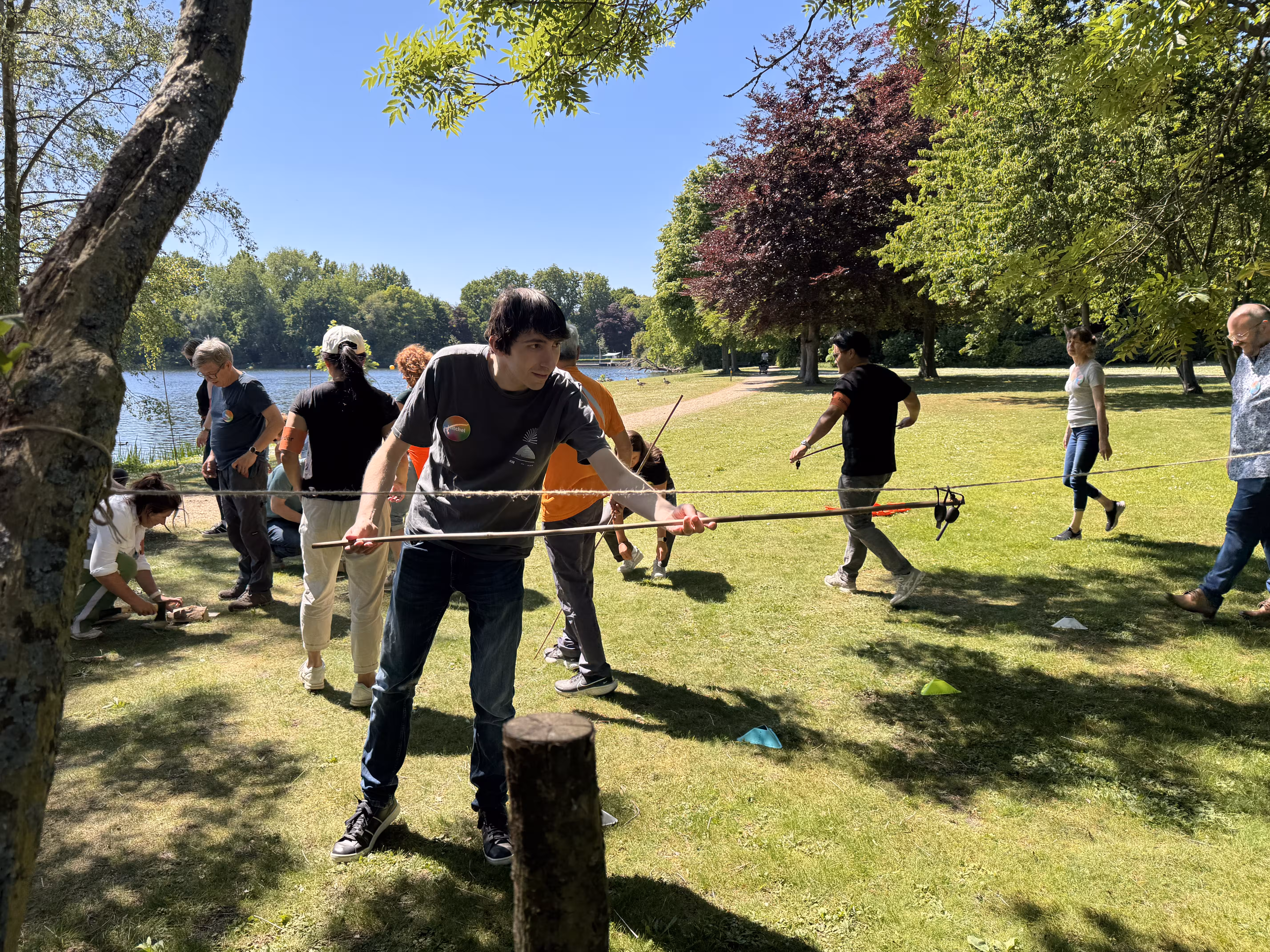 Een deelnemer probeert de vuurstarter binnen te hengelen met een bamboestok